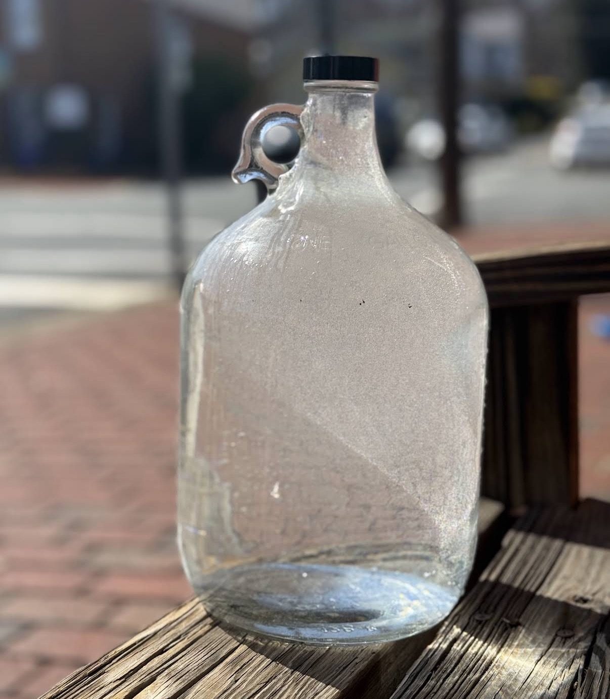 A cold glass jug of water on a weathered bench outside the Occoquan storefront